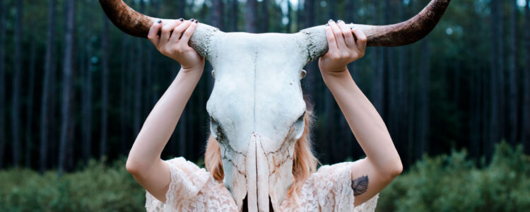 A woman holding up two horns on her head. A woman holding up two horns on her head.