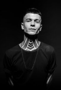 A man with tattoos on his neck and chest.
