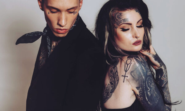 A man and woman with tattoos on their arms.