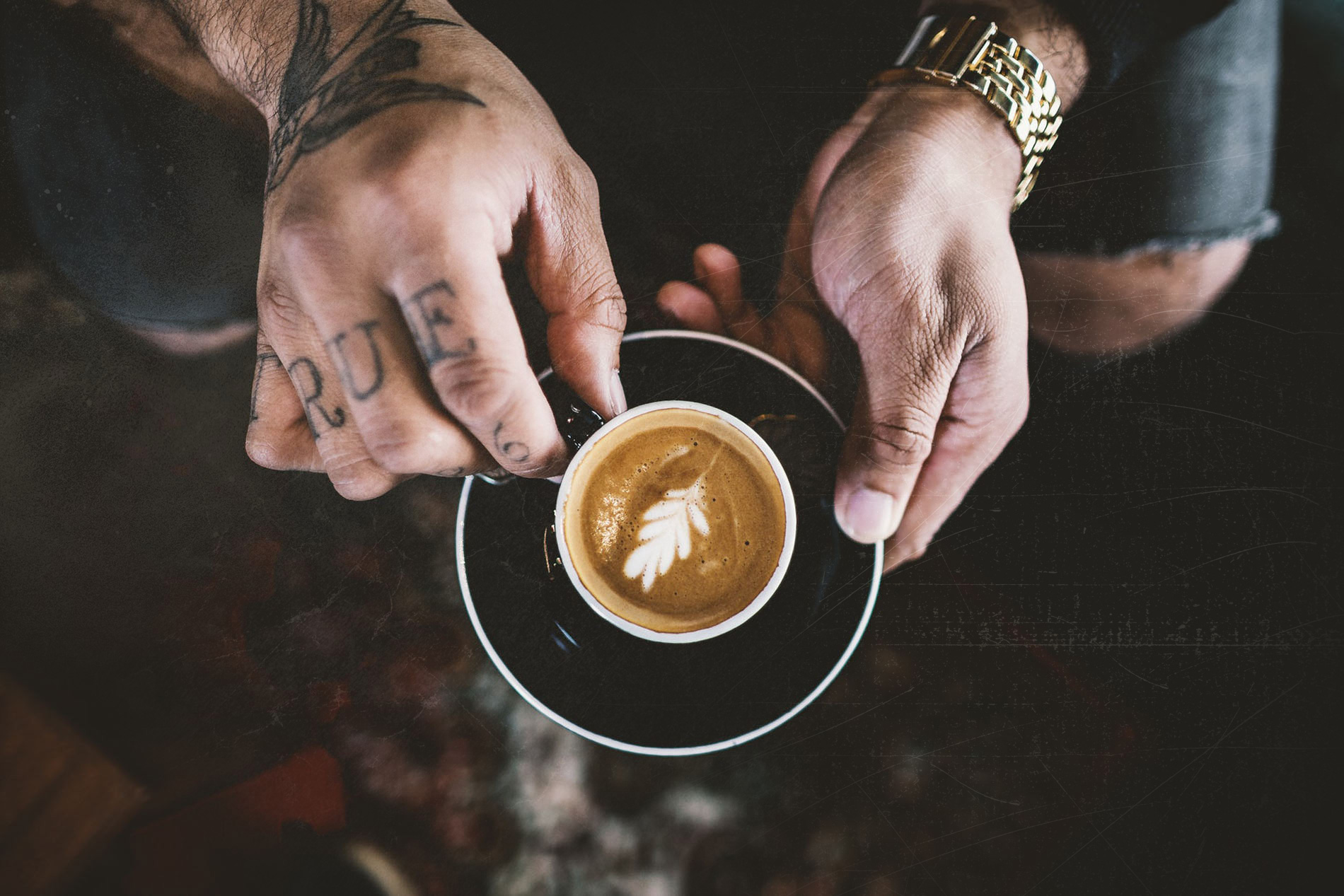 A person holding a cup of coffee on top of a saucer.