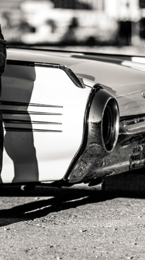 A man standing next to an old car.